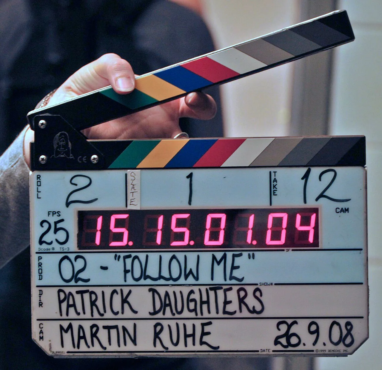 A digital clapperboard held open during a film production